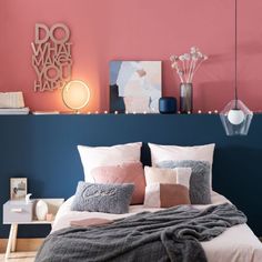 a bed with pink and blue walls in a bedroom