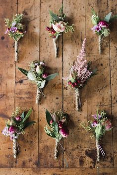 six bouquets of flowers laid out on a wooden table