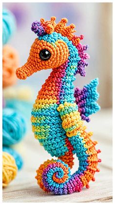 a colorful seahorse made out of multicolored yarn on top of a table