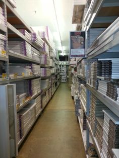 rows of shelves in a store filled with different types of papers and binder folders