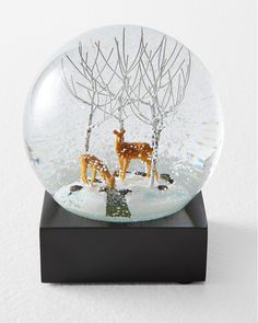 a snow globe with deer and trees inside