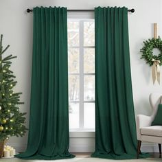 a living room with green curtains and a christmas tree