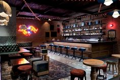 the interior of a bar with stools and tables