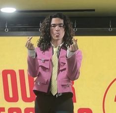 a man in a pink jacket and tie giving a speech