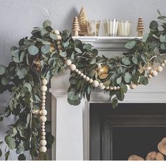 a fireplace decorated with greenery and candles