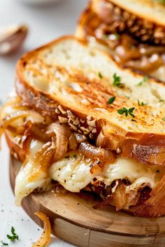 a grilled cheese and onion sandwich on a cutting board with parmesan bread