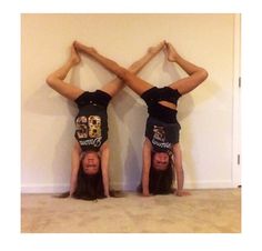 two girls doing handstands on their heads in front of a wall and floor