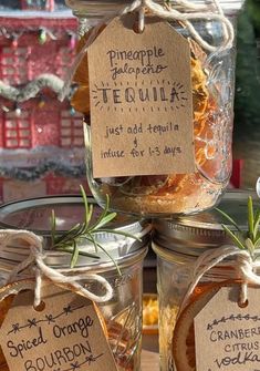 jars filled with food sitting on top of a table next to each other and tags hanging from them