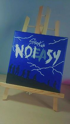 an easel with a painting on it that says no easy in front of a blue background