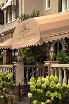 an outside view of a restaurant with flowers in the foreground