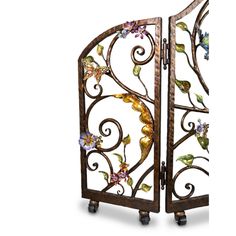 an ornate iron gate with flowers and leaves on the sides, set against a white background