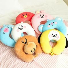 five stuffed animals are laying on a bed with their head in a pillow shaped like a teddy bear