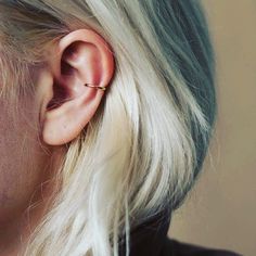 a woman with blonde hair wearing an ear piercing