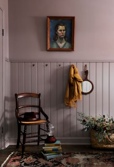 a painting hangs on the wall next to a chair with a towel draped over it