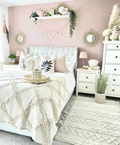 a bedroom with pink walls and white furniture