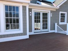 a house with wooden deck and white doors