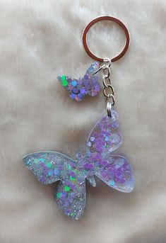 a keychain with a butterfly shaped design on it's front and back sides