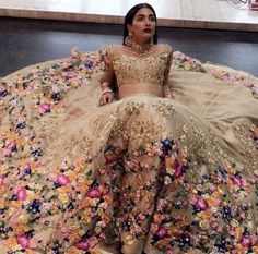 a woman sitting on the floor in a flowery dress with flowers all over it