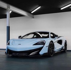 a blue and white sports car parked in a garage