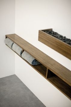 two wooden shelves with socks on them in a white walled room next to a gray tiled floor