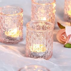 some glass candles are sitting on a table