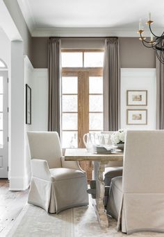 a dining room table with two chairs and a chandelier