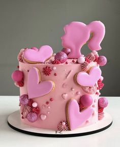 a pink cake decorated with hearts and flowers