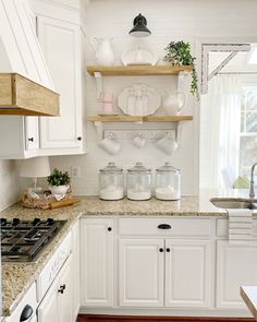 the kitchen is clean and ready to be used for cooking or baking, with white cabinets and open shelving