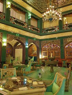 an ornately decorated restaurant with green chairs and tables