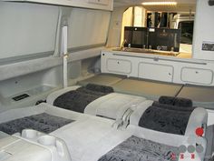 the inside of an airplane with four beds