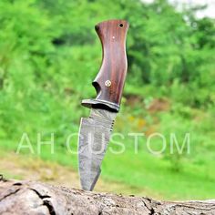 a knife with a wooden handle sitting on top of a log