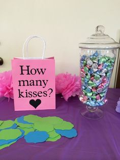 a table topped with lots of candy next to a pink bag