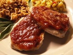 a plate with meat, rice and corn on it next to green leafy garnish