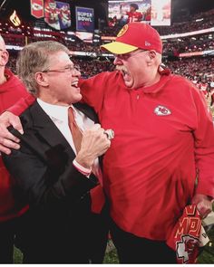 two men standing next to each other at a football game