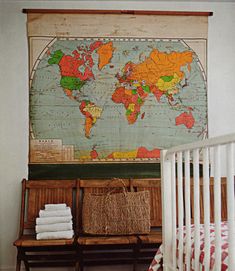 a baby's room with a map hanging on the wall and a crib