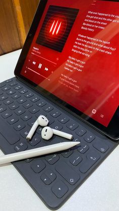 a tablet with an apple pencil and headphones on it