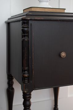 an old black cabinet with a book on top