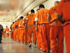 a group of men in orange prison uniforms