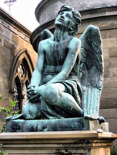 an angel statue sitting in front of a building