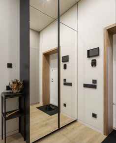 the interior of a modern home with mirrored doors and wood accents on the side wall