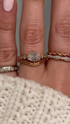 a woman's hand with three different rings on it