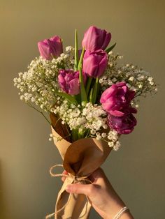 a bouquet of pink tulips and white baby's breath