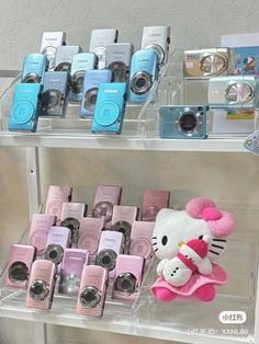 there are many different cameras on display in the store, including one with a hello kitty doll