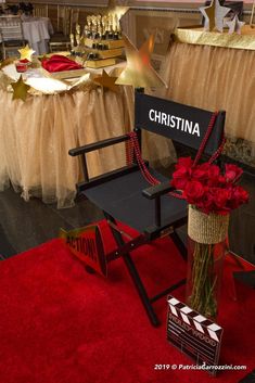 a chair with flowers in it sitting on a red carpet next to a sign that says christina