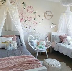 a bedroom decorated in pink and white with flowers on the wall