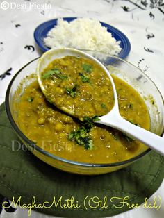 two bowls filled with food on top of a green table cloth next to white rice