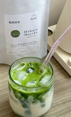 a green drink in a glass with a straw