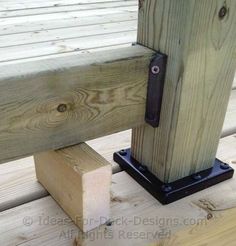 a close up of a wooden bench with metal brackets on the top and bottom posts