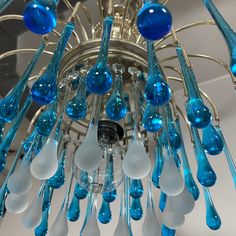 a chandelier with blue and white glass drops hanging from it's arms