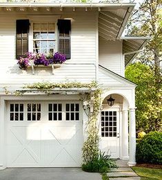 a white house with flowers in the window boxes